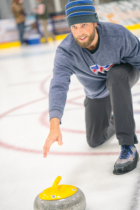 Brett Buxton sends a stone down the ice. Photo by Todd Meier.